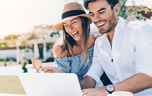 Couple smiling and shopping online with their laptop.