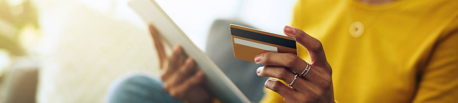 Person making a purchase on a tablet using a debit card.